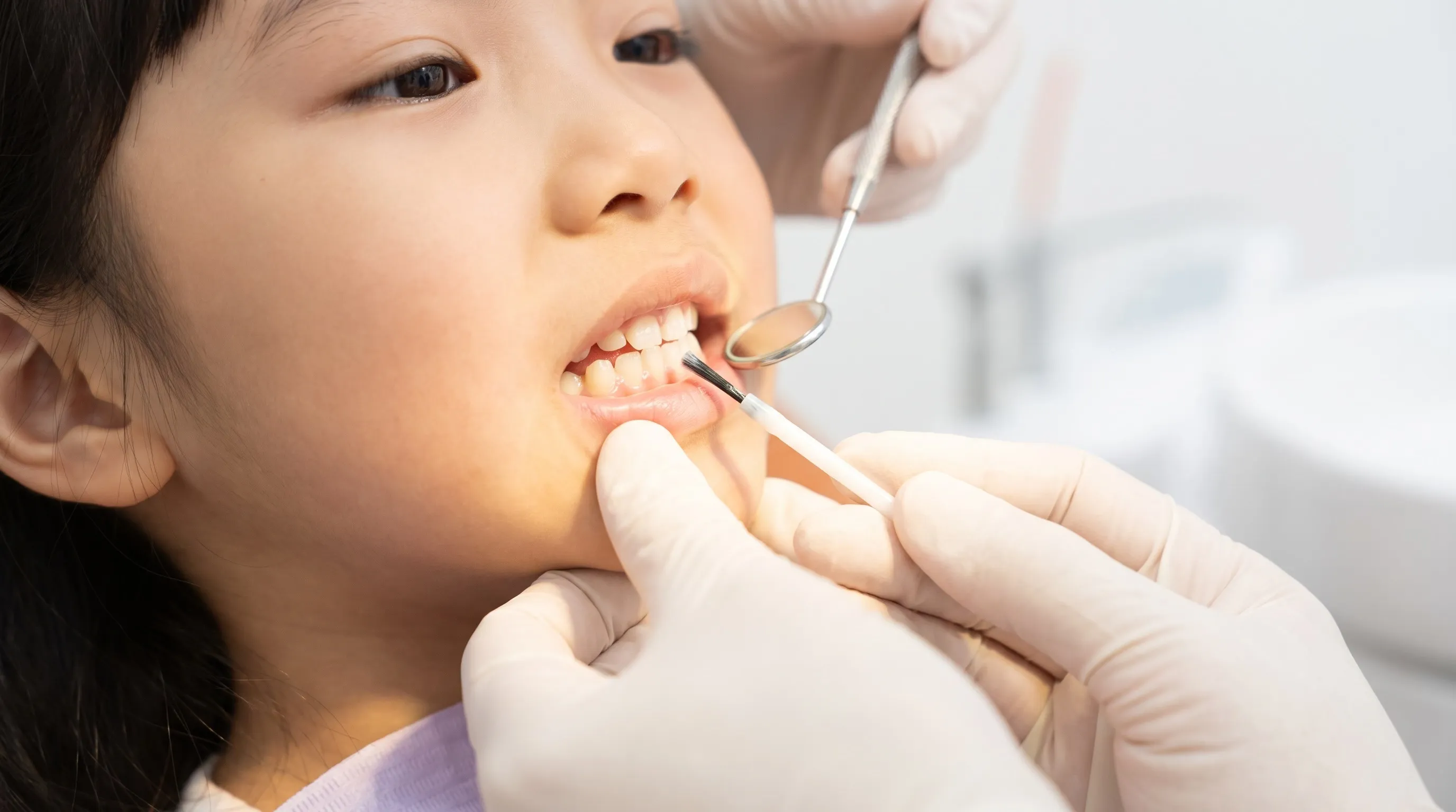 A dentist examining a child’s teeth